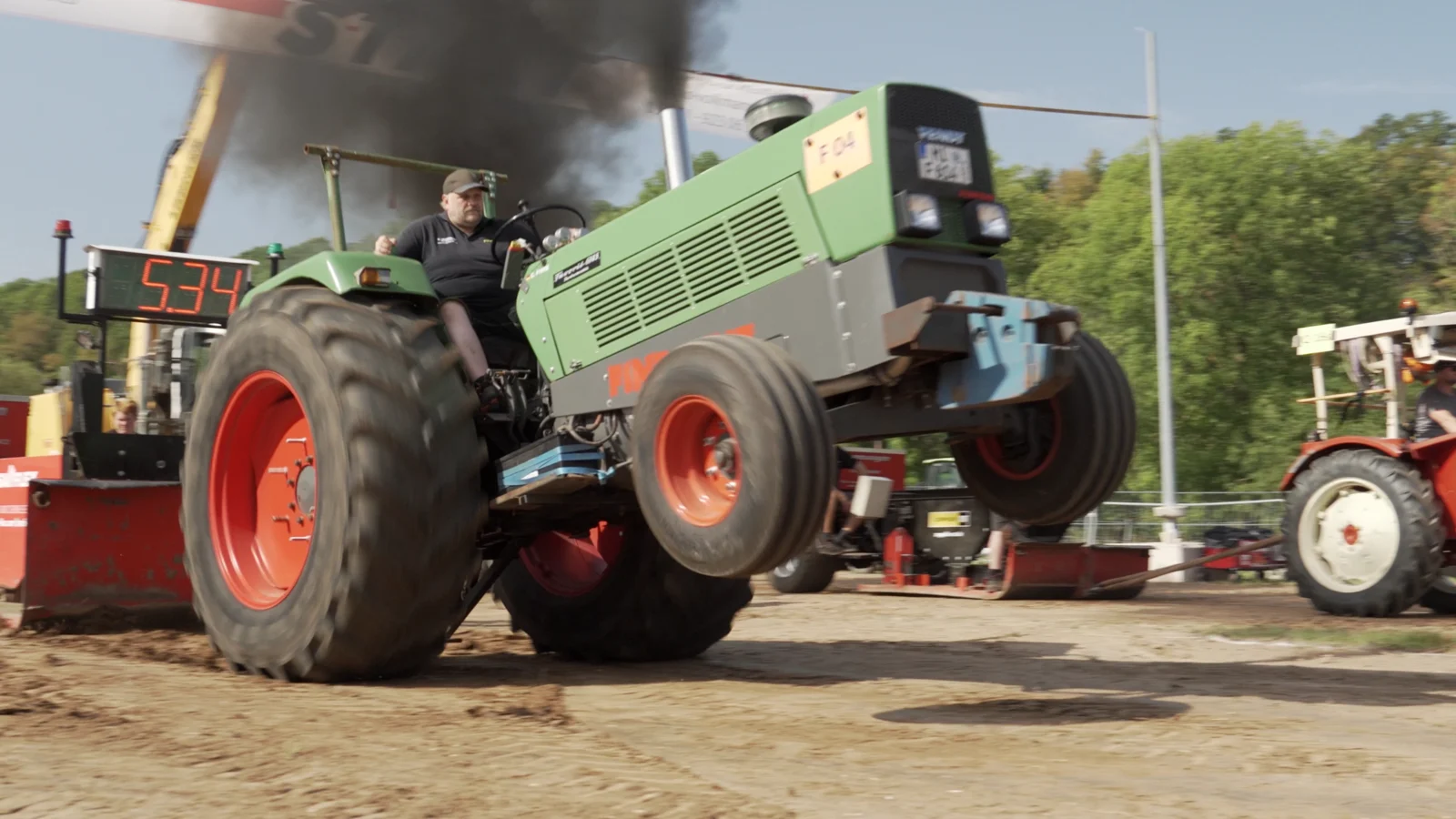 Traktor beim Pull mit angehobenen Vorderrädern auf der Trecker-Treck-Bahn